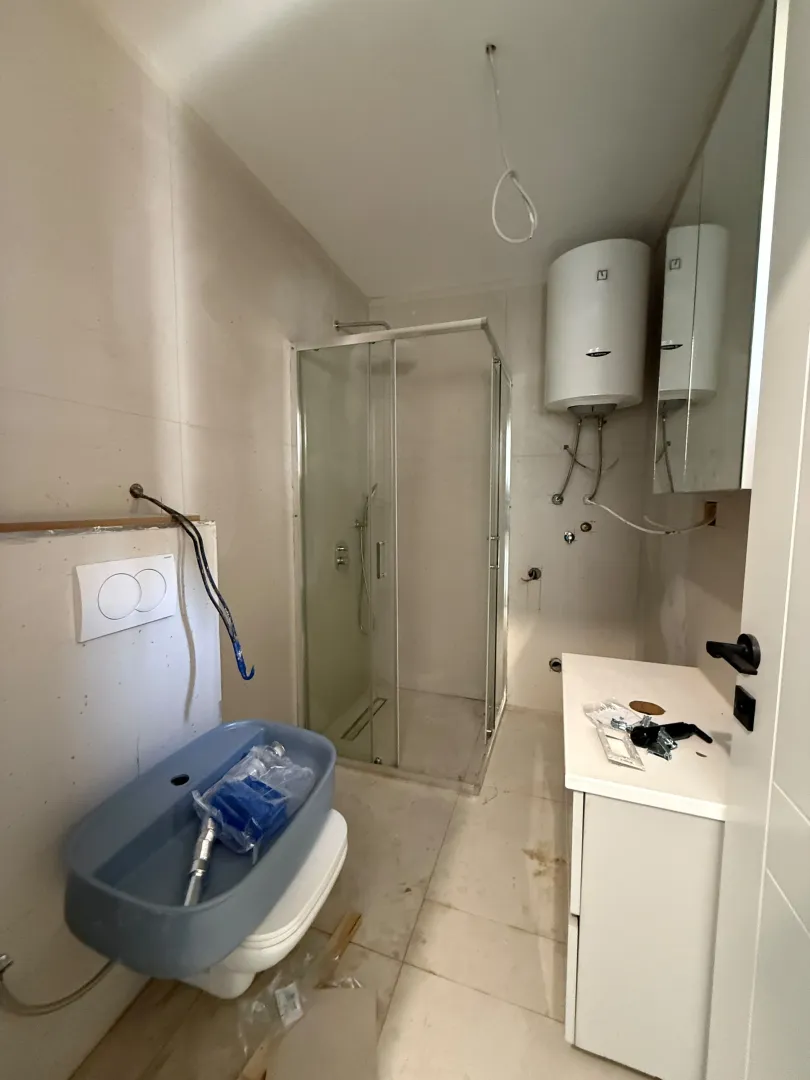 Kupatilo u fazi završnih radova sa tuš kabinom, bojlerom i sanitarijama.