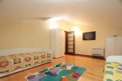 Svijetla spavaća soba sa drvenim podom, garderoberom i šarenim tepihom. - image 7