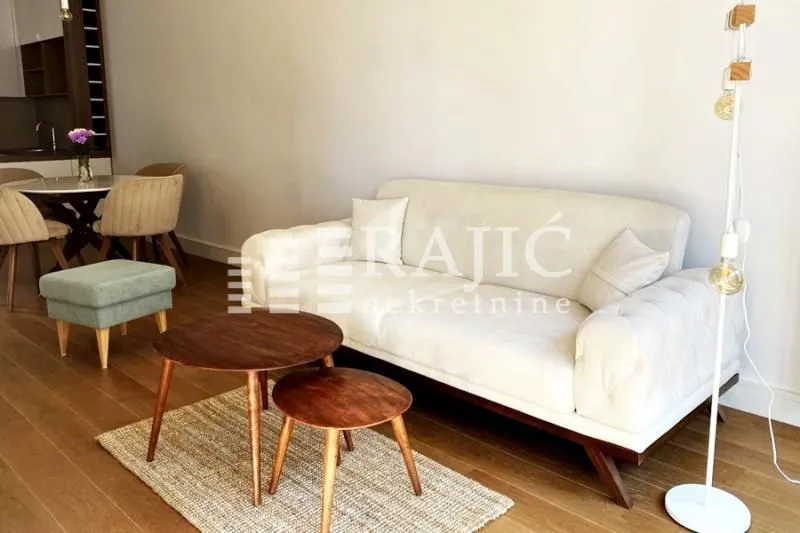 Living room with sofa and dining area in the background.