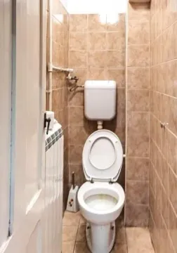 Manje kupatilo obloženo keramičkim pločicama sa WC šoljom. - image 4