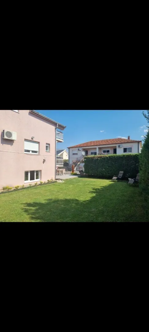 A landscaped yard with a green lawn next to the house.