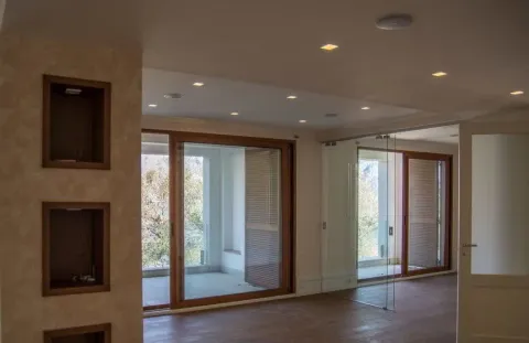 Spacious empty room with large sliding glass doors and access to a terrace. - image 14