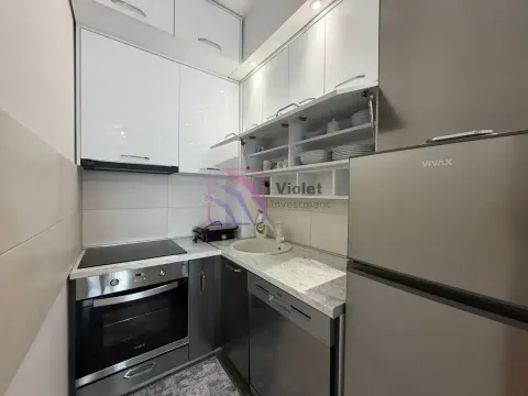 Mala bijela kuhinja opremljena ugradnim elementima i kućnim aparatima. - image 2