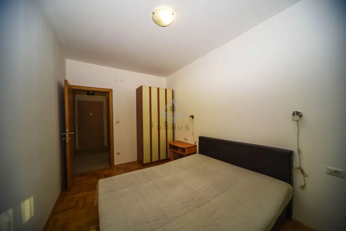 Furnished bedroom with a double bed, wardrobe, and wooden flooring.