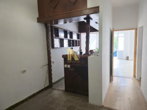 Older kitchen with a wooden bar counter and an open passage to the hallway. - image 2
