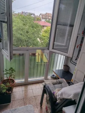 Manji zatvoreni balkon sa stolicom i pogledom na naselje. - image 9