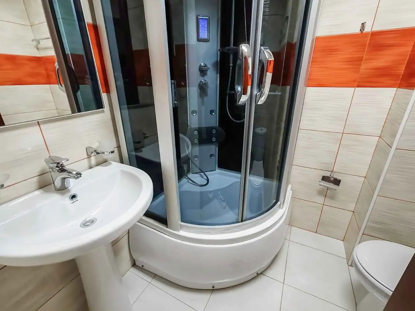 Bathroom equipped with a washbasin, shower cabin, and toilet.