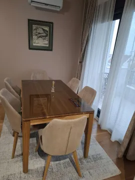 Trpezarija sa drvenim stolom i tapaciranim stolicama pored velikog prozora. - image 7