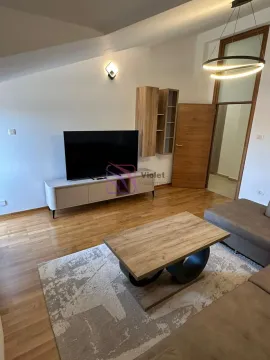 Living room with a sofa, TV, and wooden floor. - image 4