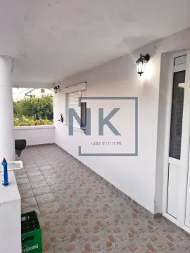 Covered terrace with tiled flooring and an entrance door. - image 12