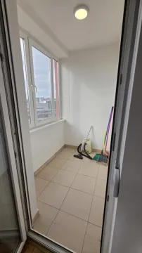 Zastakljeni balkon sa keramičkim pločicama na podu i priborom za čišćenje. - image 3