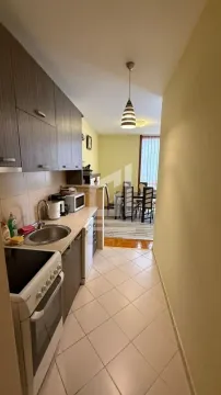 Small kitchen with wooden cabinets and appliances, looking towards the dining area. - image 3