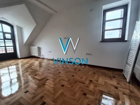 Empty attic room with parquet flooring and windows. - image 10