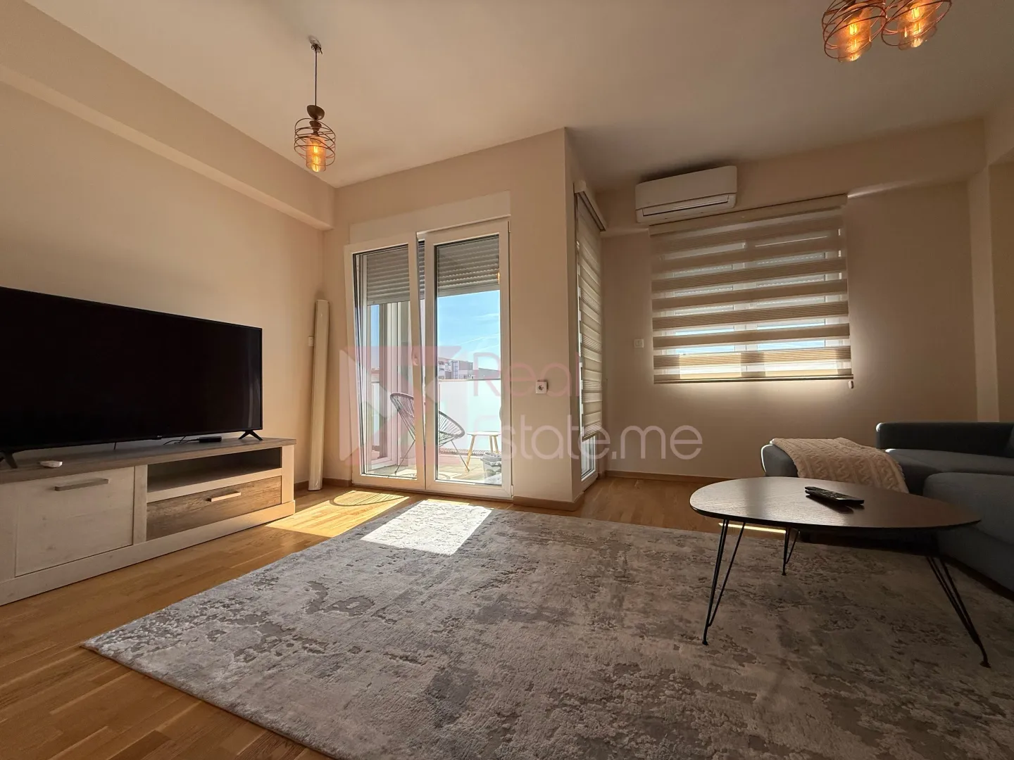 Living room with a sofa, TV, and access to the terrace.