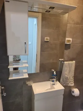 Modern bathroom with a white sink and mirror. - image 17