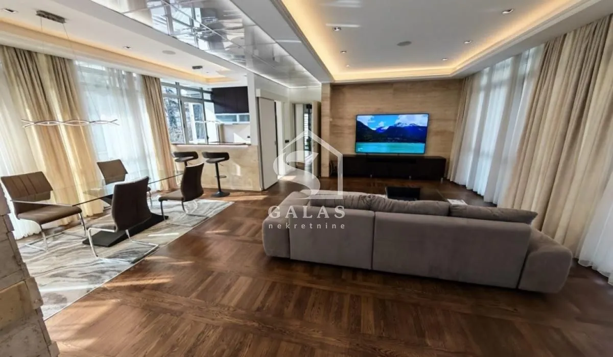 Spacious living room with a sofa, TV, and dining area.