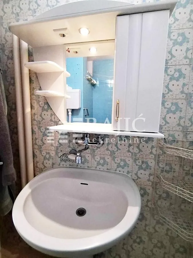 Smaller bathroom with a sink and a mirror.