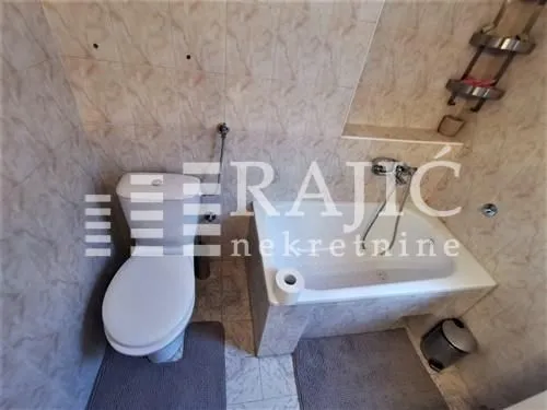 Smaller bathroom with a bathtub and toilet.