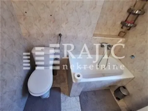 Smaller bathroom with a bathtub and toilet. - image 13