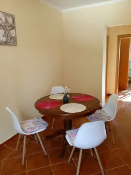 Dining area with a round table and white chairs. - image 4