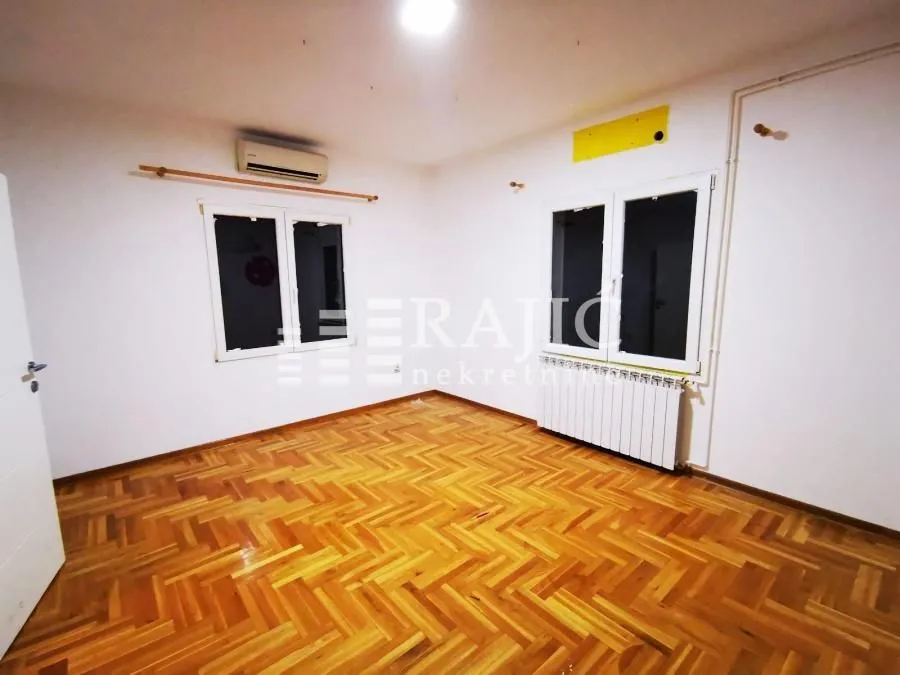 Empty room with parquet flooring and white walls.