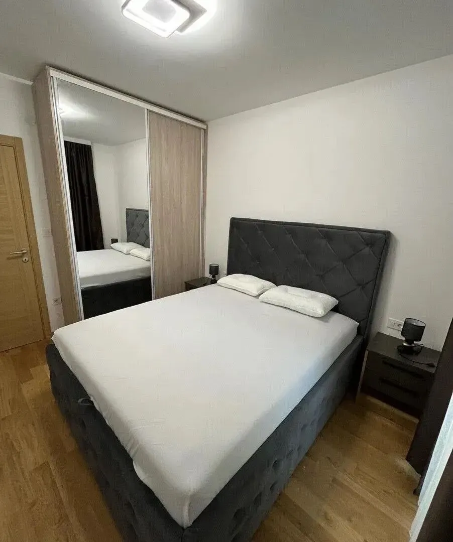 Furnished bedroom with a double bed and a built-in wardrobe with a mirror.