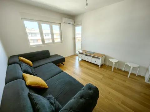 Dnevna soba sa ugaonom garniturom, TV komodom i izlazom na terasu. - image 3