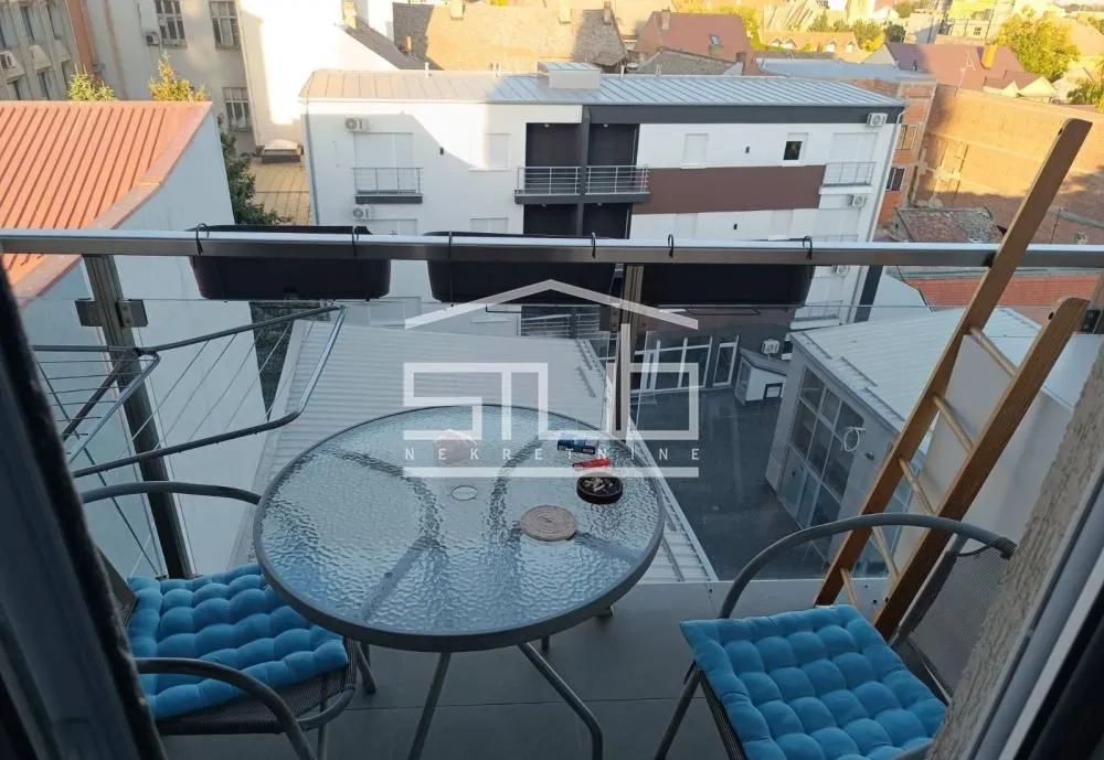 Small furnished balcony with a glass table and chairs.
