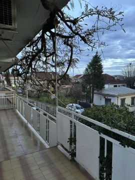Dugačka terasa sa bijelom ogradom i pogledom na naselje. - image 15