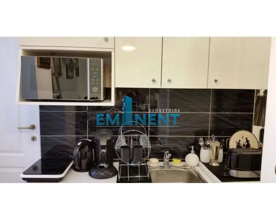 Small equipped kitchen with countertop and kitchen cabinets.