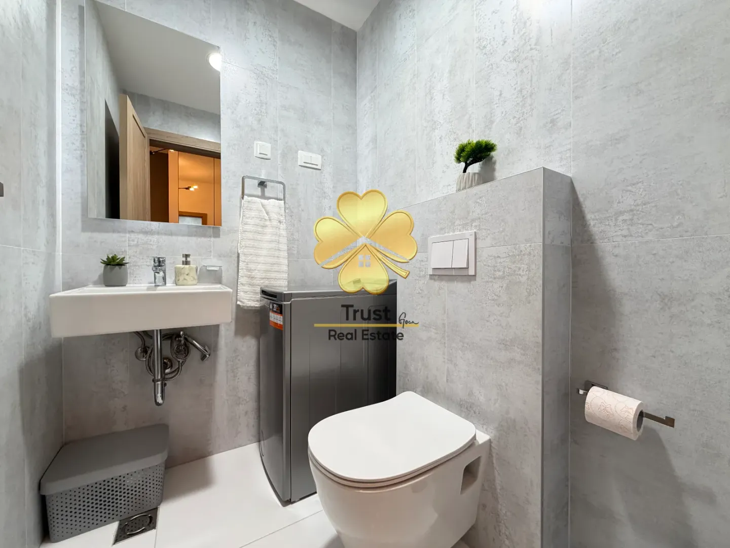 Modernly equipped bathroom with a washbasin, toilet, and washing machine.