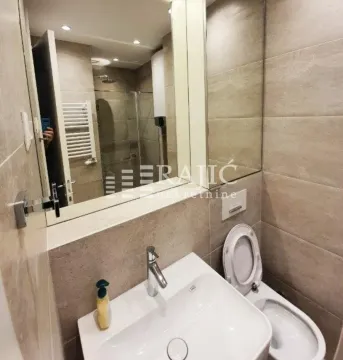Modernly equipped bathroom with a washbasin, toilet, and walk-in shower. - image 11