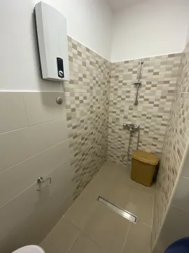 Bright bathroom featuring a walk-in shower area with ceramic tiles. - image 20