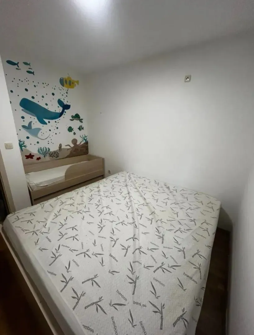 Dječija spavaća soba sa krevetom i zidnim motivima.