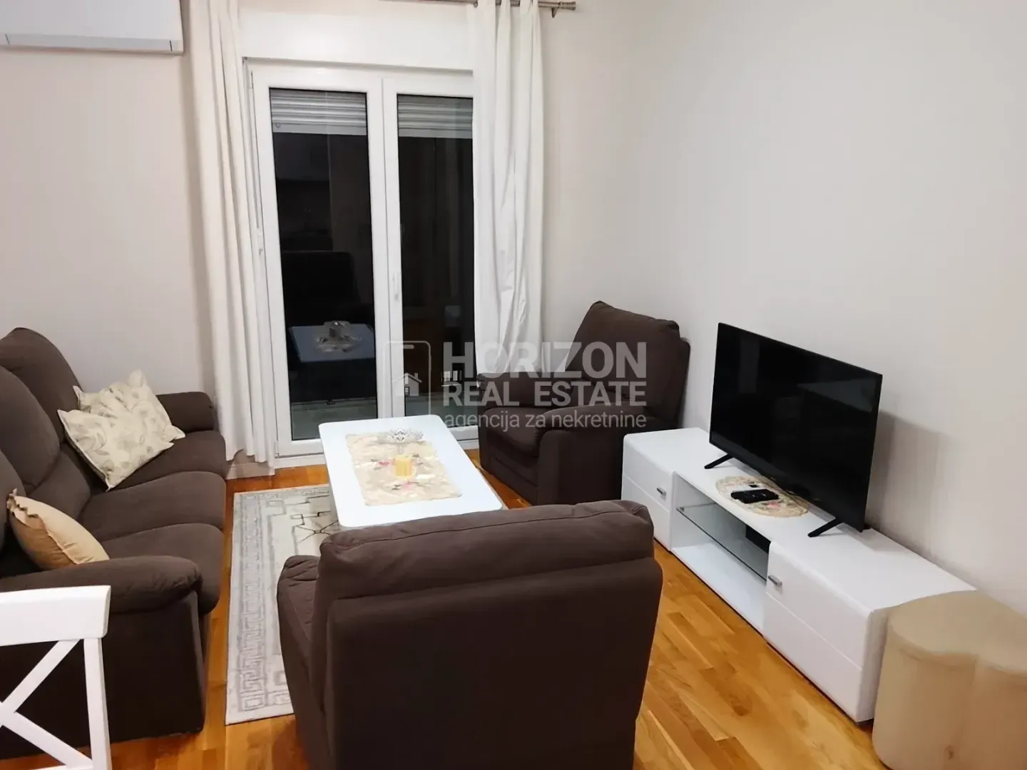 Living room with sofa set, coffee table, and TV.
