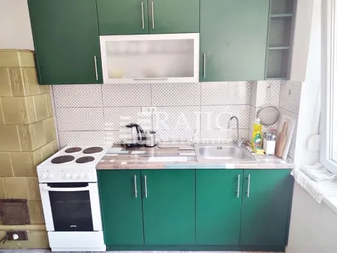 Small kitchen with green cabinets and a stove. - image 5