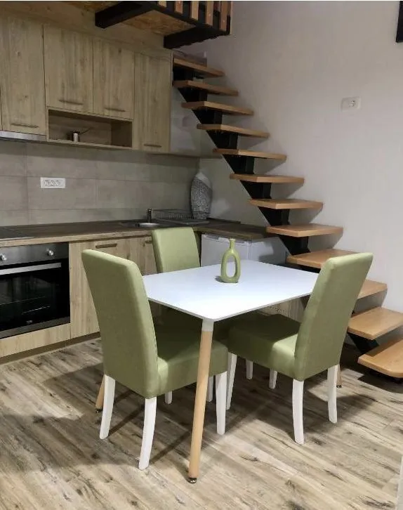 Small kitchen with a dining table and staircase.