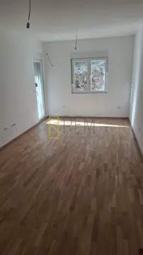 Prazna soba sa parketom i bijelim zidovima. - image 2