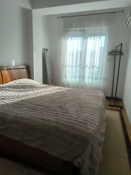 Comfortable bedroom with a double bed and a window with white curtains. - image 5