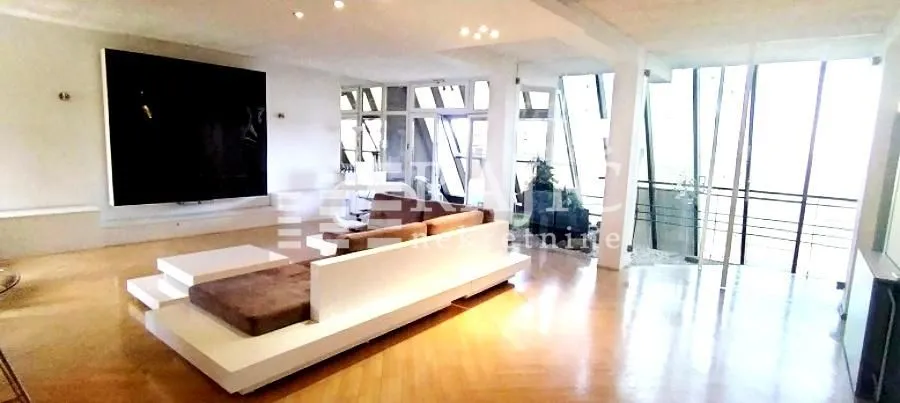 Spacious living room with modern furniture and large windows.