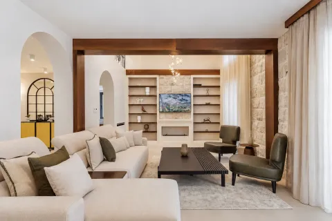 Spacious living room with a sofa set, wooden beams, and wall shelving. - image 13