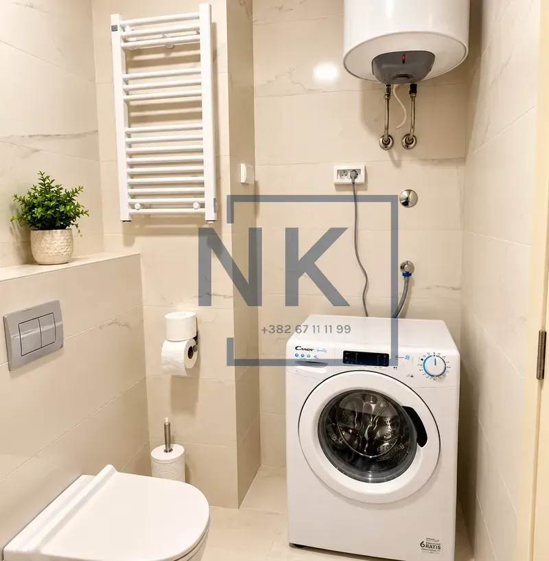 Savremeno opremljeno kupatilo sa veš mašinom i ugradnim wc šoljom.