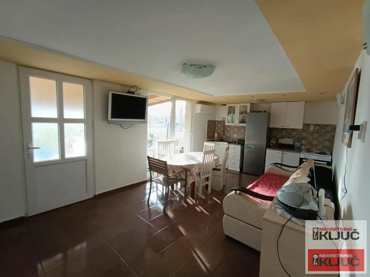 Living room with a dining area and kitchen in the background.