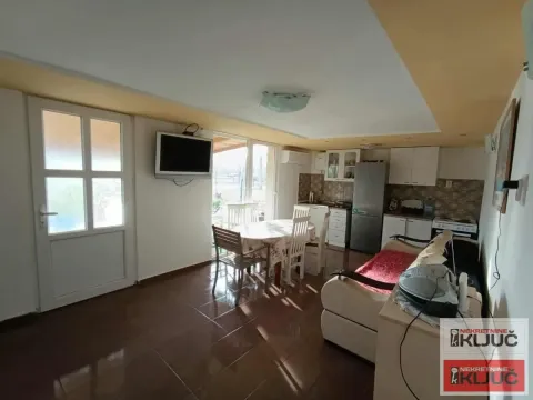 Living room with a dining area and kitchen in the background. - image 9
