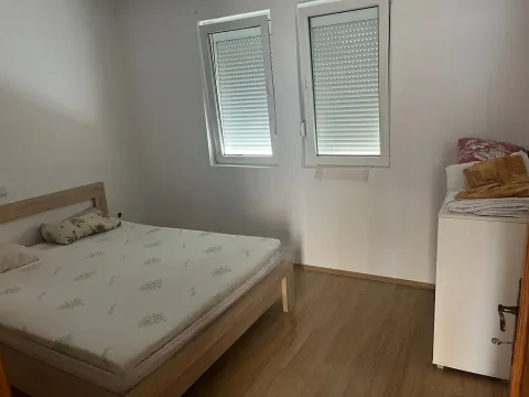 Manja spavaća soba sa krevetom i dva prozora. - image 4