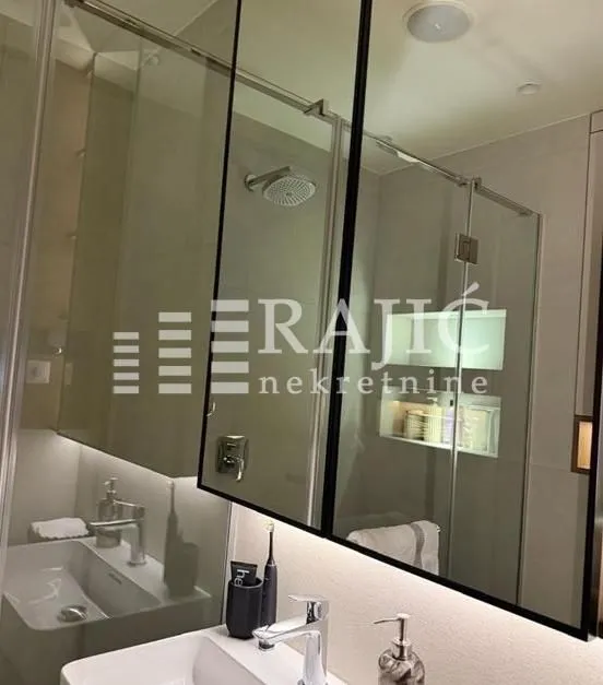 Modern bathroom equipped with a washbasin and walk-in shower.