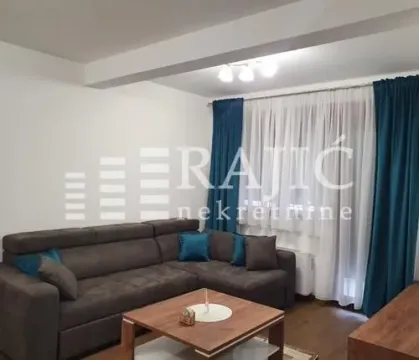 Living room with a sectional sofa and a window with blue curtains. - image 3