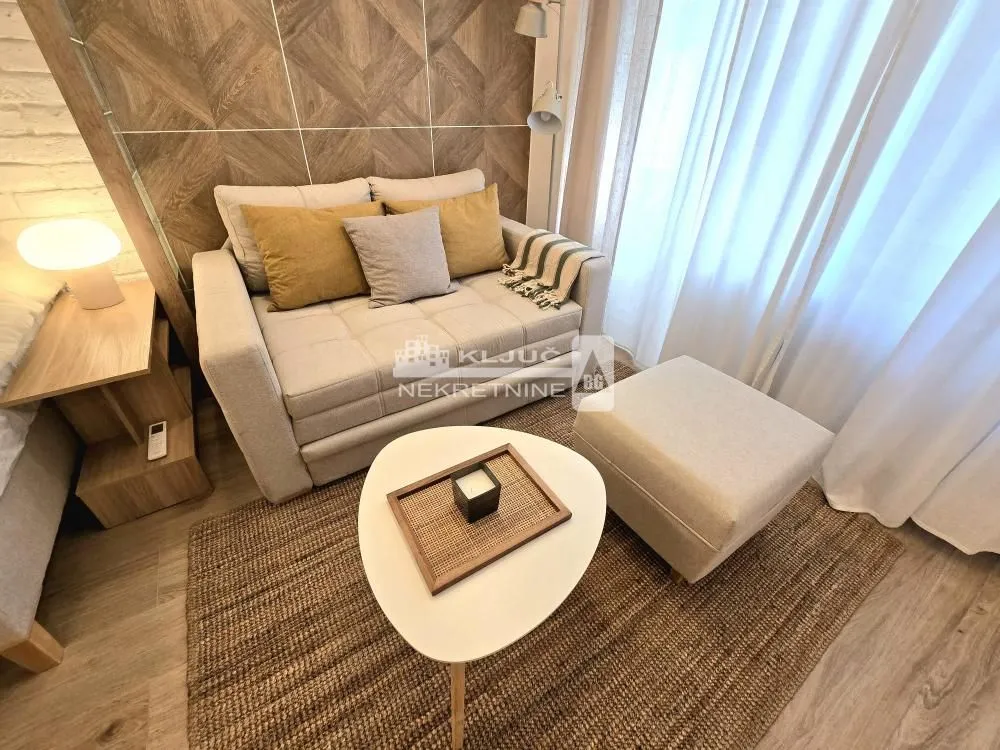 Smaller living room with a comfortable armchair, coffee table, and decorative wall.