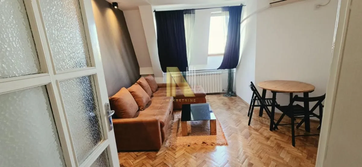 Dnevna soba sa garniturom i trpezarijskim stolom.