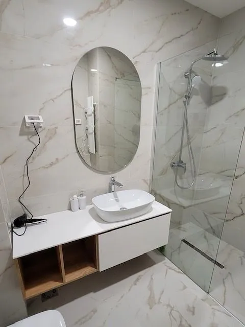 Modern bathroom with a sink, mirror, and walk-in shower.
